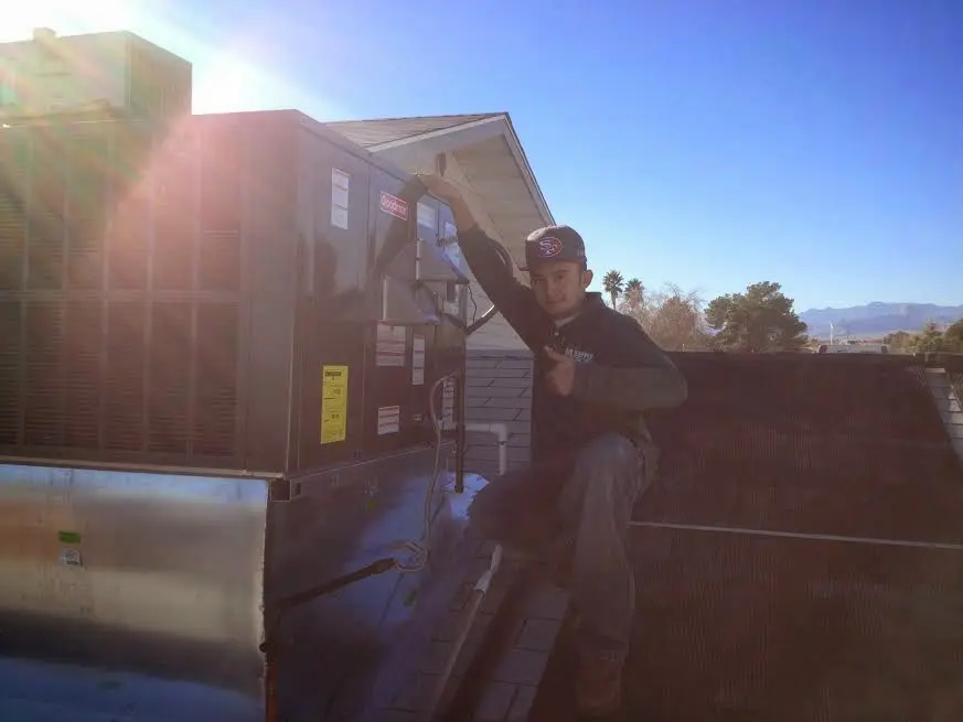 HVAC technician performing Boiler Repair on a rooftop unit in Soledad